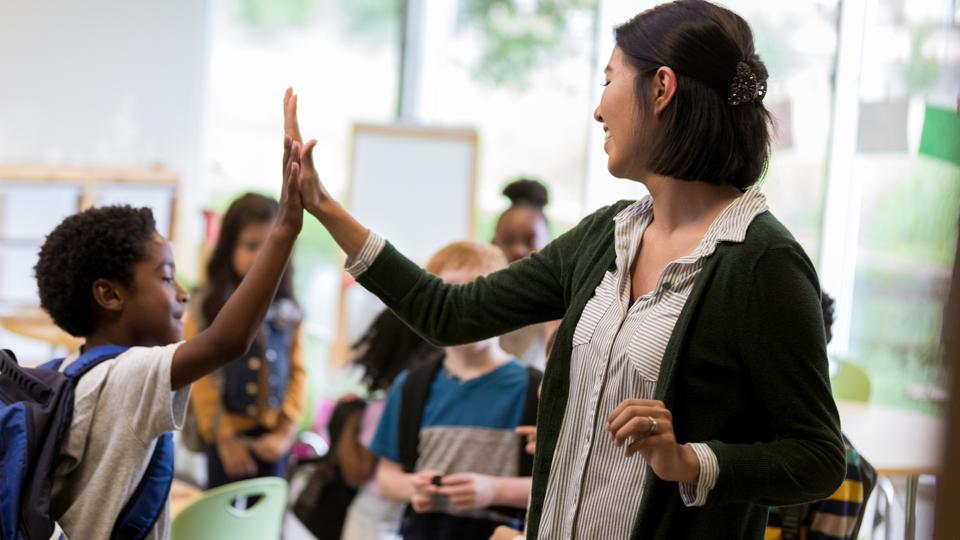 students and teacher handshaking