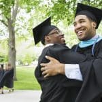 two students smile and hug each other